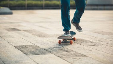 Kaykaycı şehir dışında kaykay yapıyor.