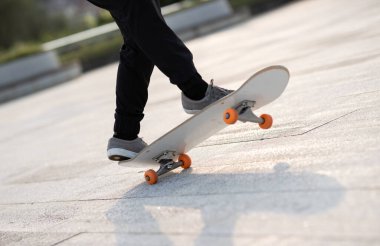 Kaykaycı şehir dışında kaykay yapıyor.