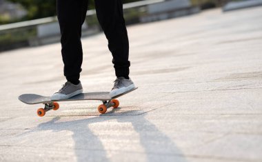 Kaykaycı şehir dışında kaykay yapıyor.