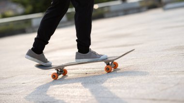 Kaykaycı şehir dışında kaykay yapıyor.