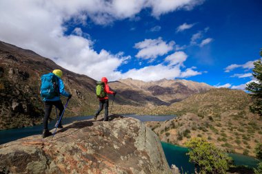 Güzel kış dağlarında yürüyüş yapan iki kadın gezgin.