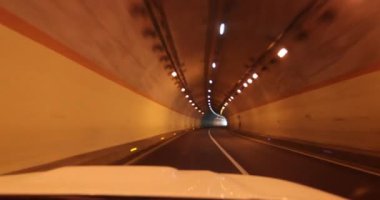 Yeraltı tünelinde ışıklarla giden araba.