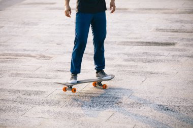 Kaykaycı şehir dışında kaykay yapıyor.