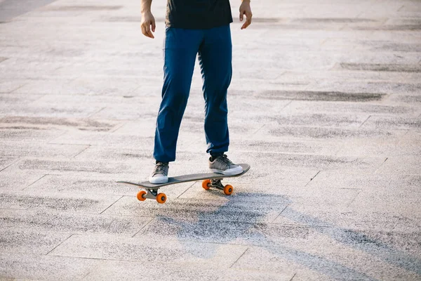 Kaykaycı şehir dışında kaykay yapıyor.