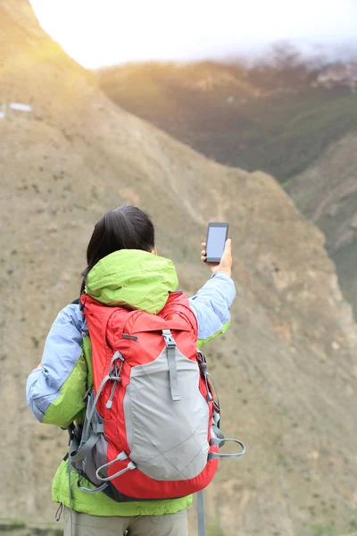 Mujer fotógrafa tomando fotos en la montaña — Foto de Stock