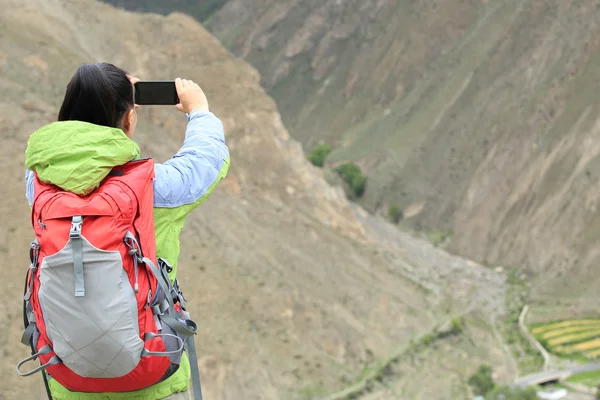 Kobieta fotograf fotografia biorąc w góry — Zdjęcie stockowe