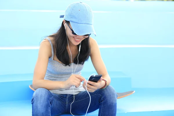 Vrouw skateboarder luisteren muziek — Stockfoto