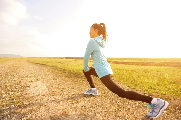 Woman stretching legs before running — Stock Photo, Image