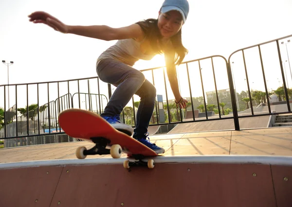 Mladá žena skateboardingu v sunrise — Stock fotografie