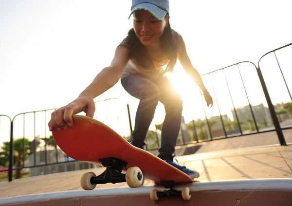 Jeune femme skateboard au lever du soleil — Photo