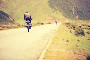 tibet, Çin'in yüksek dağlarda asfalt yol boyunca dağ bisikleti rides