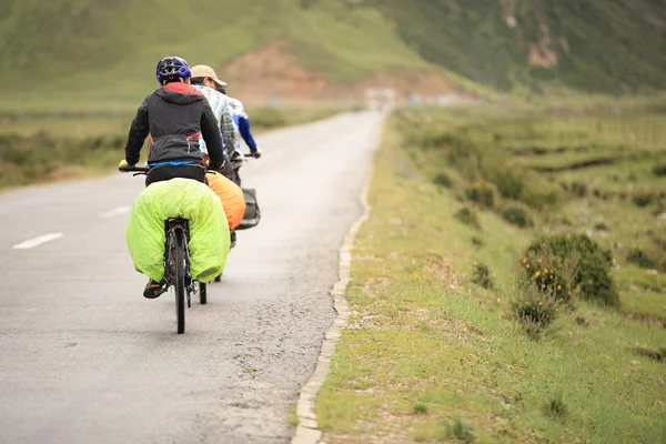Mountainbike Rider längs vägen i kickbergen av tibet, Kina — Stockfoto