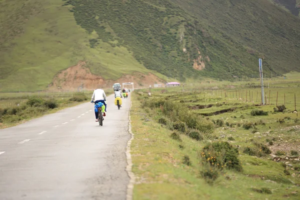 tibet, Çin'in yüksek dağlarda asfalt yol boyunca dağ bisikleti rides