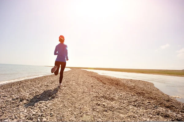 stock image Runner athlete running on stone beach of qinghai lake.