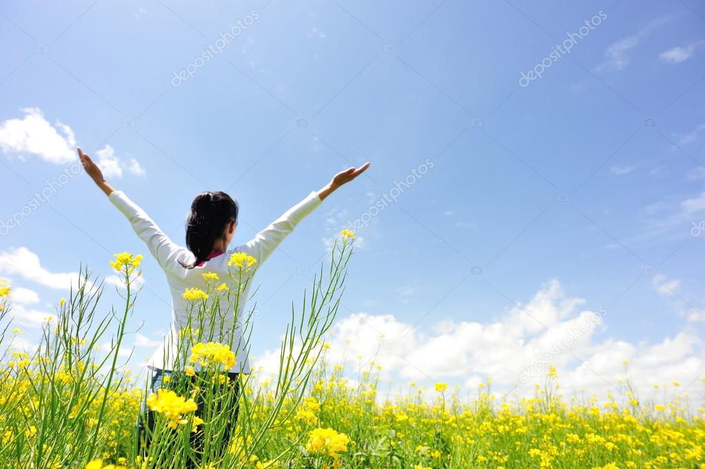 Cheering woman open arms at cole flower field