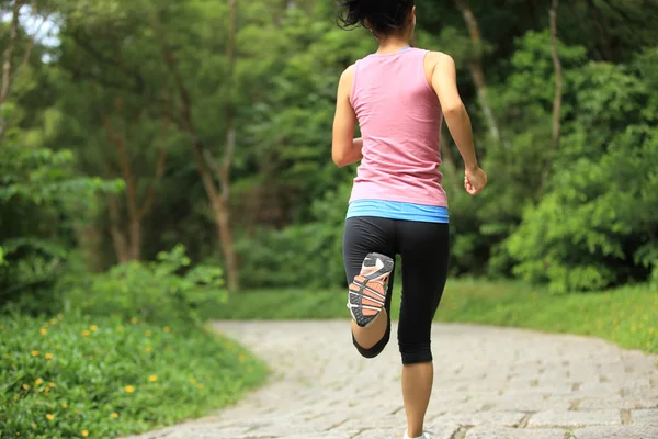 年轻的健康妇女在森林小径上奔跑 — 图库照片
