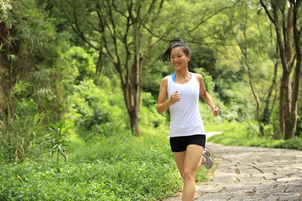 年轻的健康妇女在森林小径上奔跑 — 图库照片