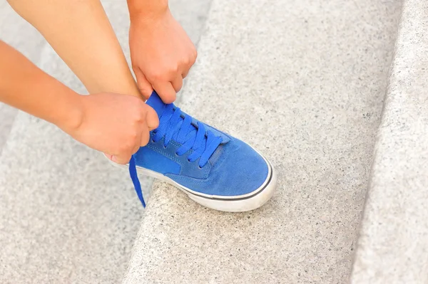 Genç fitness kadın merdivenlerde ayakkabı bağcığı bağlama