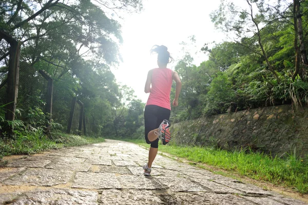 Женщина бежит по лесной тропе — стоковое фото