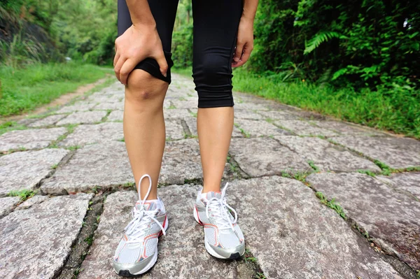 Mujer sostener su rodilla lesionada —  Fotos de Stock