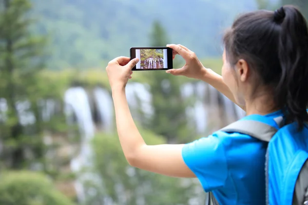 Žena turistické brát fotografie s Kobaltová modř telefon — Stock fotografie