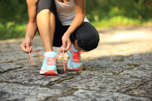 Женщина-бегун, завязывающая шнурки — стоковое фото