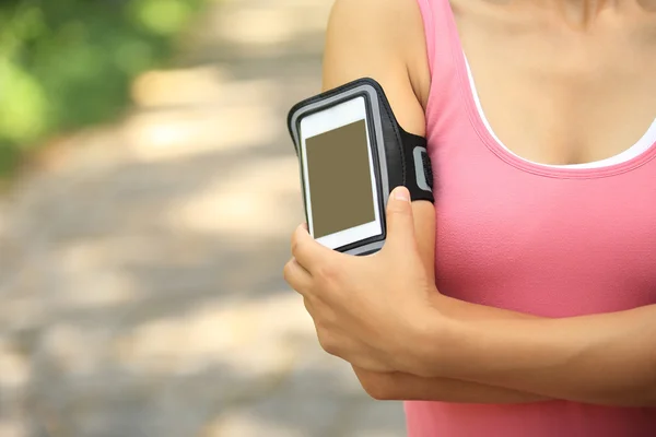 Atleta corridore ascoltare musica da smart phone lettore mp3 bracciale smartphone . — Foto Stock