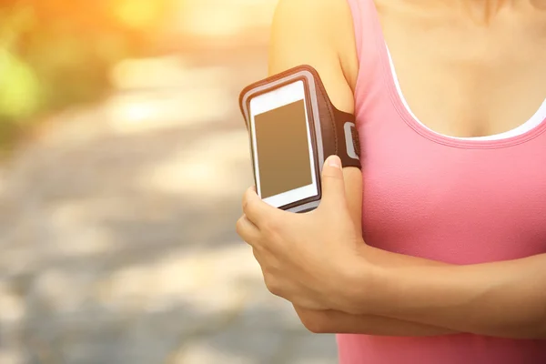 Atleta corridore ascoltare musica da smart phone lettore mp3 bracciale smartphone . — Foto Stock