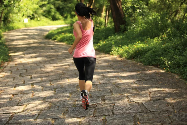 Frau läuft auf Waldweg — Stockfoto