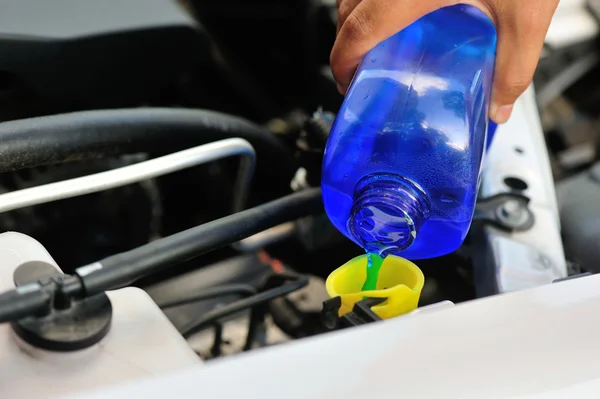 Manos añadiendo auto limpiador de vidrio para el coche —  Fotos de Stock