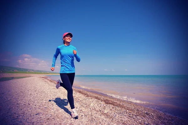 Löpare idrottsman körs på sten stranden av qinghai sjö — Stockfoto