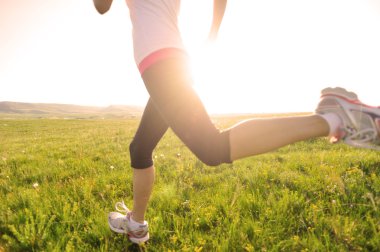 runner atlet bacaklar çim sahil üzerinde çalışan.