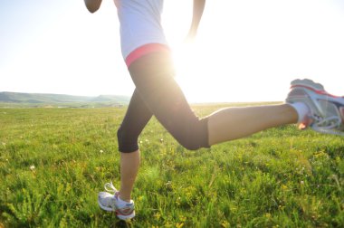 runner atlet bacaklar çim sahil üzerinde çalışan.