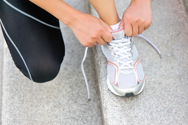 Joven corredora atando cordones en las escaleras — Foto de Stock