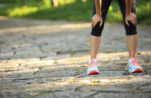 Frau hält ihr verletztes Knie — Stockfoto