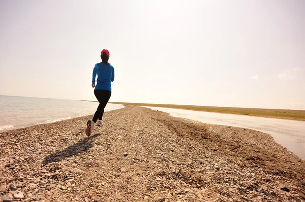 Atleta corridore che corre sulla spiaggia di pietra del lago qinghai — Foto Stock