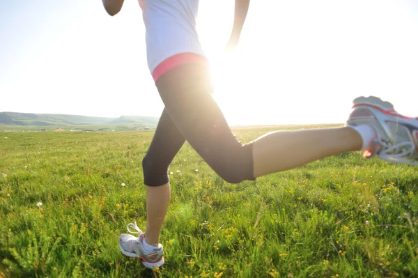 Jambes athlète coureur courir sur herbe bord de mer . — Photo