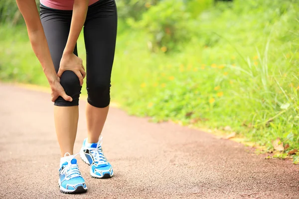 Mujer sostener su rodilla lesionada — Foto de Stock