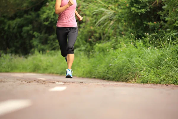 Oung fitness femme jambes en cours d'exécution au sentier forestier — Photo