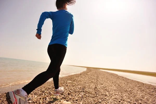 Corredor atleta corriendo en la playa de piedra del lago Qinghai —  Fotos de Stock