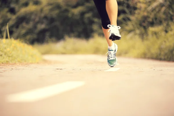 Oung fitness piernas de mujer corriendo en el sendero del bosque — Foto de Stock