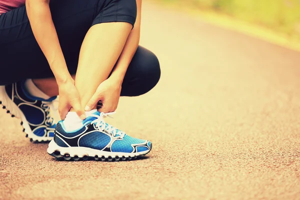 Woman runner hold her twisted ankle — Stock Photo, Image