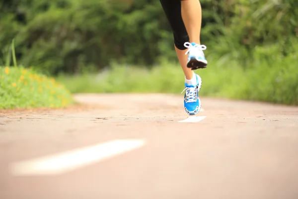 Oung fitness piernas de mujer corriendo en el sendero del bosque — Foto de Stock