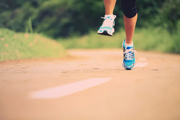 Oung fitness femme jambes en cours d'exécution au sentier forestier — Photo