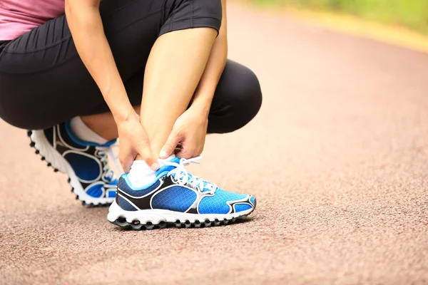 Woman runner hold her twisted ankle — Stock Photo, Image