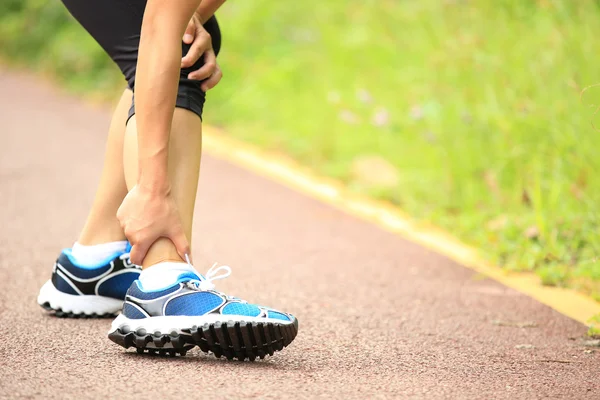 Kobieta biegacz zawierać jej skręcona kostka — Zdjęcie stockowe