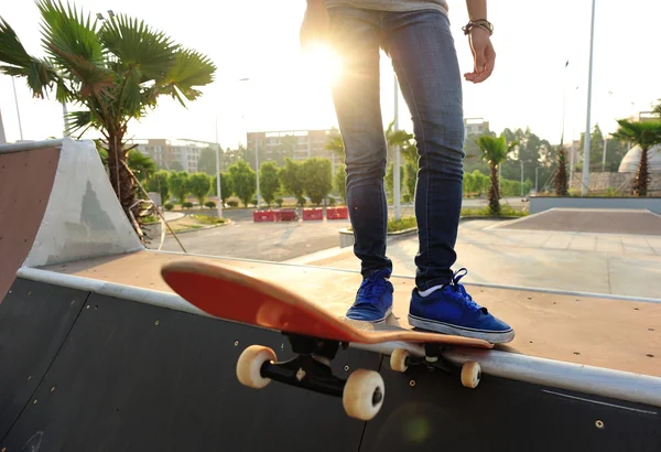 Skateboarding mulher pernas no nascer do sol skatepark — Fotografia de Stock