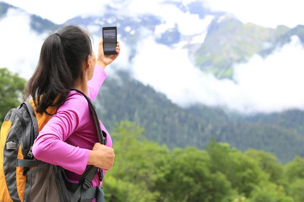 Kobieta wycieczkowicz biorąc zdjęcie z telefonu komórkowego na szczyt w Tybecie, Chinach — Zdjęcie stockowe