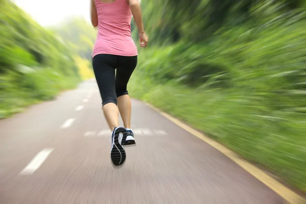 Young fitness woman running at forest trail — Stock Photo, Image