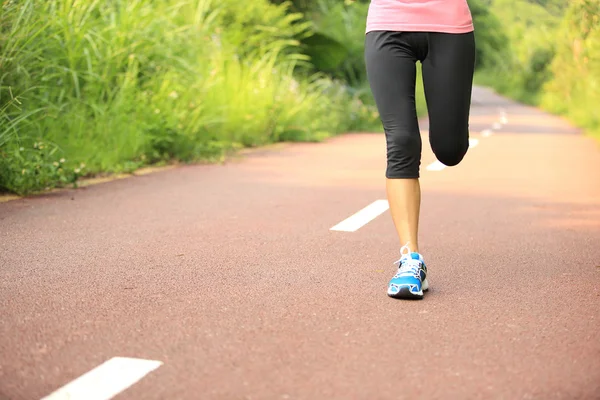 Oung fitness femme jambes en cours d'exécution au sentier forestier — Photo